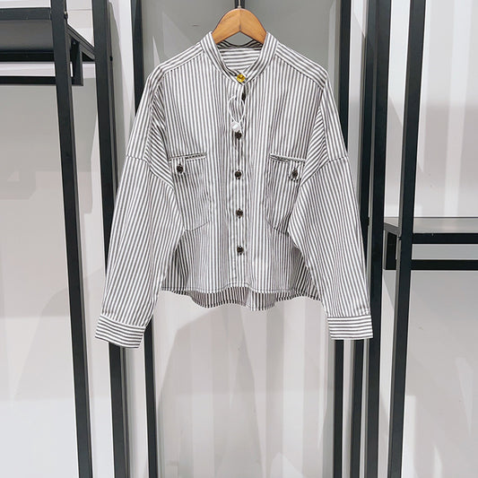 Camisa casual con hombros descubiertos, cuello alto pequeño, decoración con hebilla dorada y rayas blancas y negras 